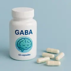 Biała butelka z napisem GABA i grafiką mózgu, obok kilka kapsułek. Zastanawiasz się gaba co to?