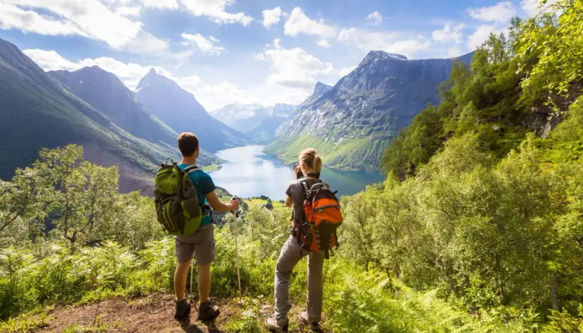 Trekking co to? Dwóch turystów z plecakami podziwia malowniczy fiord i góry.