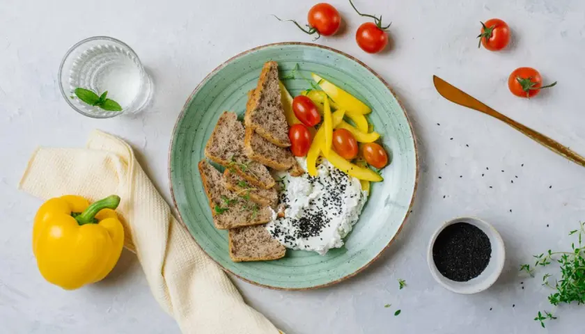 Twarożek z czarnuszką, pieczywo, pomidorki i papryka – idealne na śniadanie zgodne z dieta wysokobiałkowa przepisy.