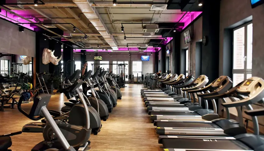 Nowoczesna siłownia z rzędami bieżni i orbitreków. Sprawdź atrakcyjną **Medicover Sport cenę** i zacznij trening!