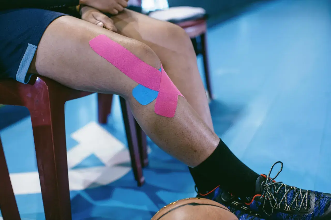 Chondromalacja rzepki ćwiczenia: sportowiec z plastrami na kolanie, gotowy do treningu.